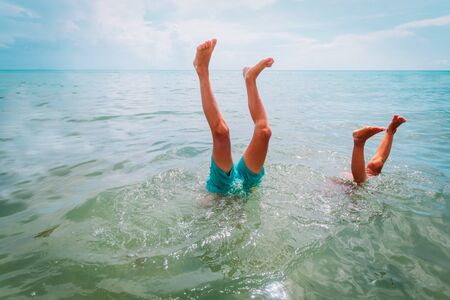 kids making handstand in sea, kids vacation funの写真素材
