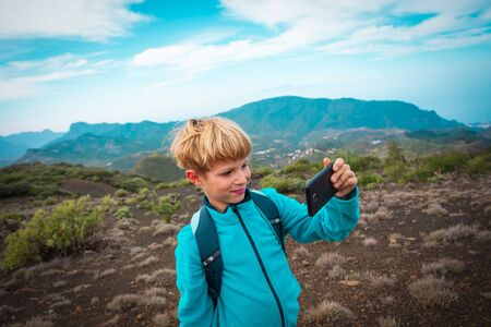 little boy making selfie while travel by in mountainsの写真素材