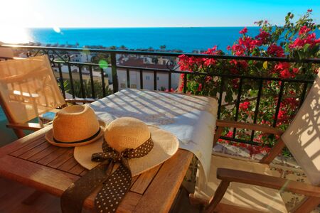two hats on balcony terrace with sea view, travel conceptの写真素材