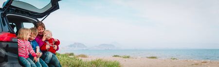 happy mother with kids travel by car near beachの写真素材