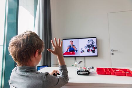 kid building robot with online robotic technology lesson