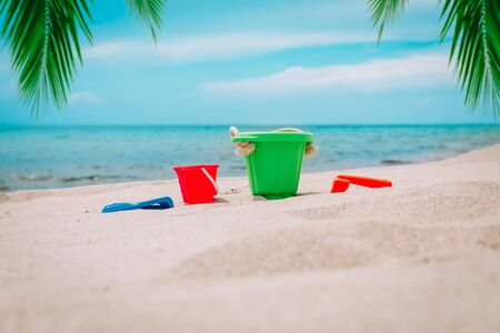 kid toys on tropical sand beach with palm trees, family vacationの写真素材