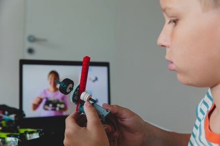 kid building robot with online robotic technology lesson