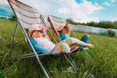 little girls relax in garden, kids spend summer in the countryの写真素材