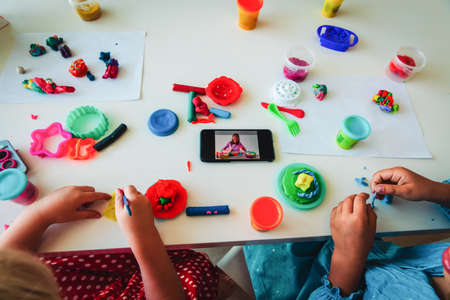 Kids play with clay molding shapes during online lessonの写真素材