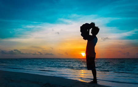 Father and little daughter silhouettes play at sunsetの写真素材