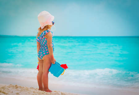 little girl play with sand on summer beachの写真素材