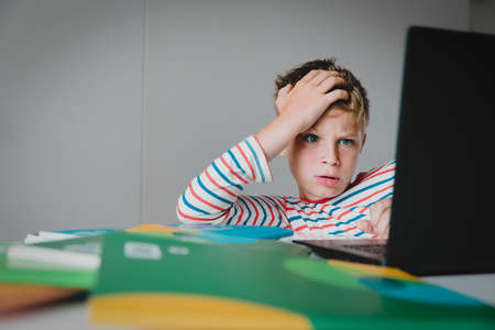 Bored and agressive kid looking at computer, boy angry to get too much homework