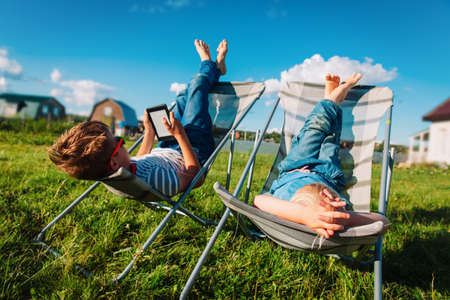 kids relax in garden, boy and girl spend summer in the country