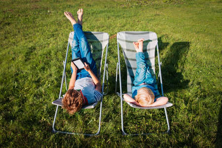 kids relax in garden, boy and girl spend summer in the countryの写真素材