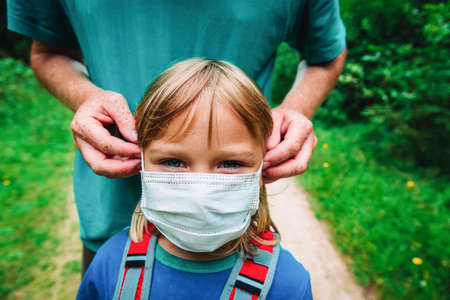 father put mask on daughter before going to school