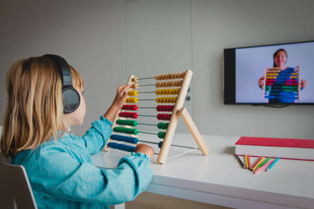 little girl learning at home, kid doing online math lessonの写真素材