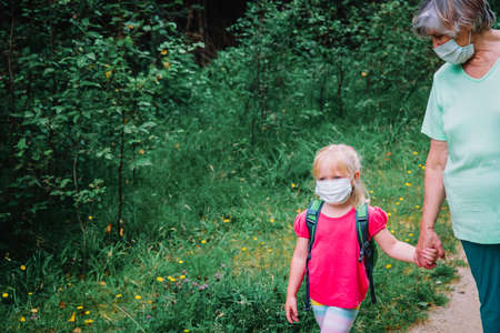 grandmother with child wearing mask outsideの写真素材