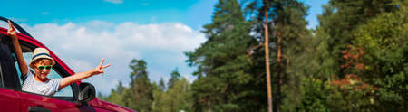 happy kid enjoy travel by car in summer natureの写真素材