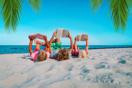 kids -boy and girls- read books on beach, family vacationの写真素材