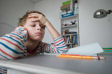 Child tired and bored of doing homework, kid stressed from learningの写真素材