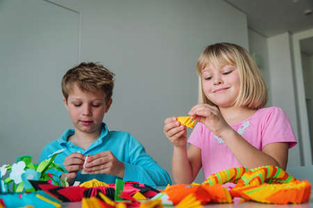kids making origami crafts with paper at home, indoor crafts for kidsの写真素材
