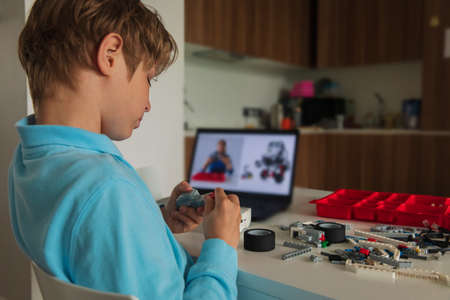 kid building robot with online robotic technology lessonの写真素材