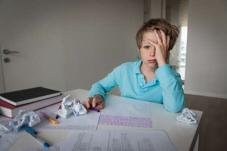 sad boy tired and stressed of learning, doing homeworkの写真素材