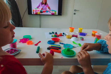 Kids play with clay molding shapes during online lessonの写真素材