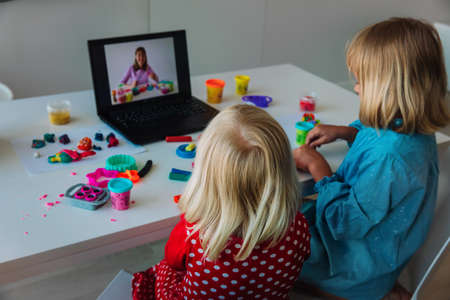 Kids play with clay molding shapes during online lessonの写真素材