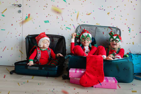 happy kids packing suitcases for christmas travelの写真素材
