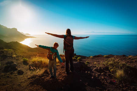 silhouette of happy mother and son travel at sunset mountainsの写真素材