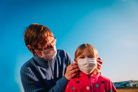 father put mask on daughter outside, coronovirus protectionの写真素材