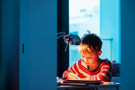 kid doing homework late evening or early morning, procrastinationの写真素材