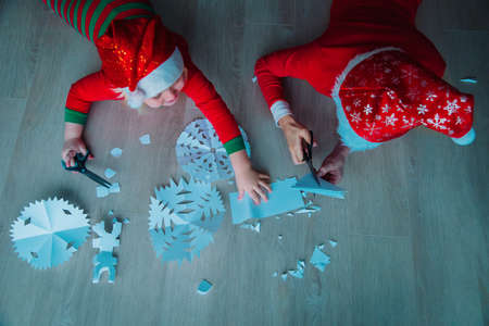 boy and girl cutting snowflakes from paper, Christmas craftsの写真素材