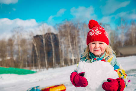little girl play with snow in winter natureの写真素材