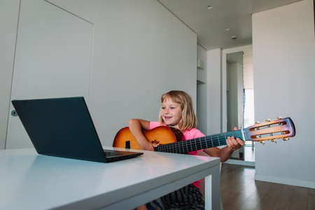 cute girl having guitar lesson online at homeの写真素材