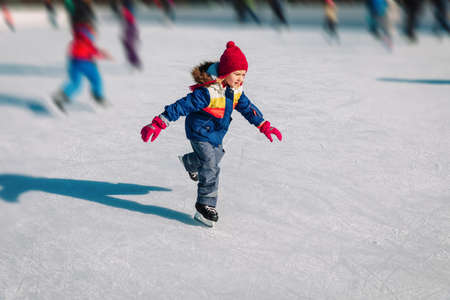 little girl skating in winter snow, seasonal sport for kidsの写真素材