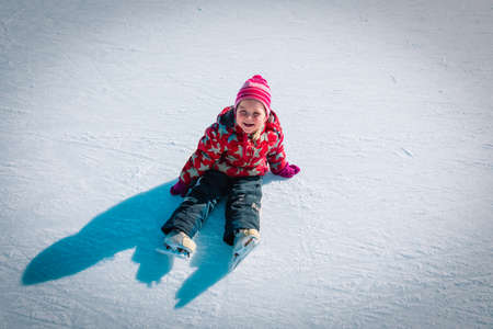 little girl skating in winter snow, seasonal sport for kidsの写真素材