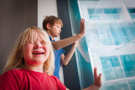issues for kids staying home, girl crying indoors, COVID difficultiesの写真素材