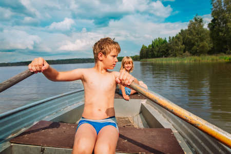 happy kids on boat ride in lake, family on vacationの写真素材