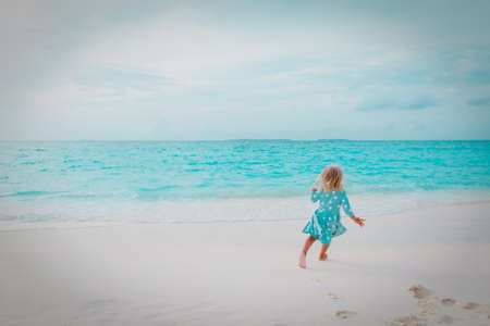 happy little girl run and play on tropical beachの写真素材