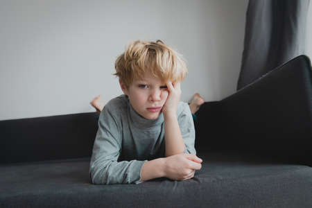 exhausted and bored kid at home, boy in stress