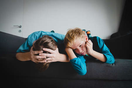 sad child with stressed father staying home, family on lockdownの写真素材