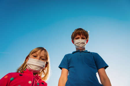boy and girl with masks outside, kids during coronovirus pandemic