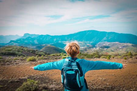 happy young boy enjoy hiking in mountainsの写真素材