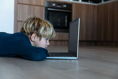 kid looking at computer at home, online learning and remote educationの写真素材