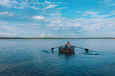 happy kids on boat ride in lake, active family vacationの写真素材