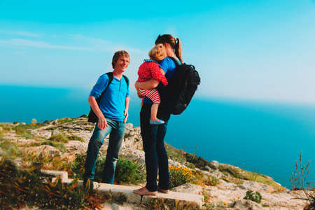 family with little daughter hiking in mountains