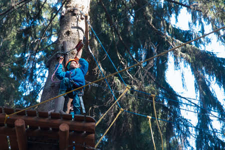 happy boy climbing in adventure activity park