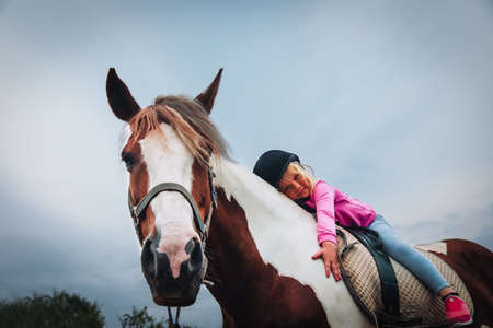 happy little girl hug horse, horse theraphyの写真素材