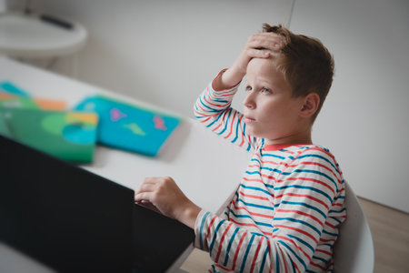 Child tired and bored of doing homework, kid stressed from learning