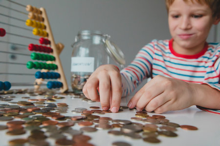 boy counting money, kid saving coins, personal finances for kidsの写真素材