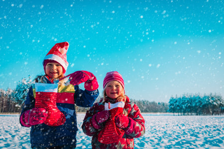 happy kids with christmas presents in winter natureの写真素材