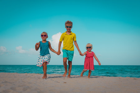 happy boy and girsl walk on beach vacationの写真素材